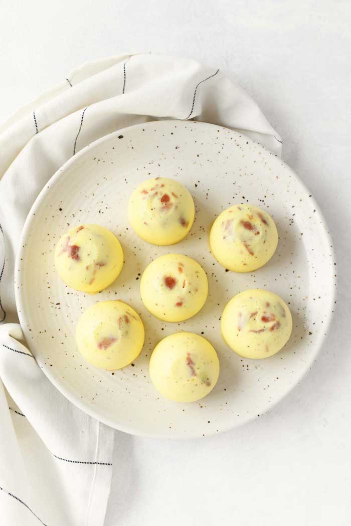 A speckled plate with bacon egg bites on top.